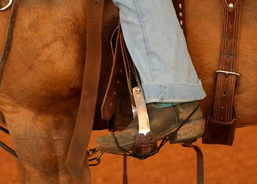 Black Better Bands secured around a rider's boot and stirrup