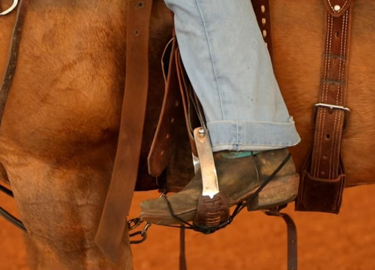 Black Better Bands secured around a rider's boot and stirrup